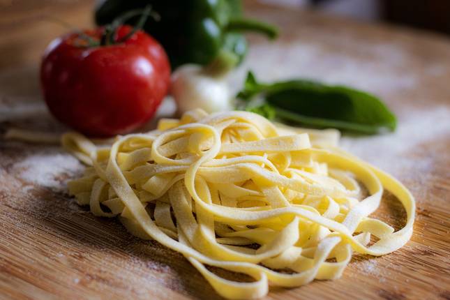 Pasta mit Tomate und Paprika im Hintergrund